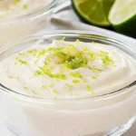 Keto Key Lime Pie Mousse: A Creamy Low-Carb Delight 6 Creamy keto key lime pie mousse topped with lime zest in a clear glass dessert bowl.